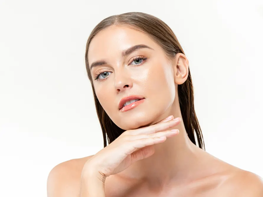 Stock photograph of a model: a woman with smooth, even skin rests her hand under her chin