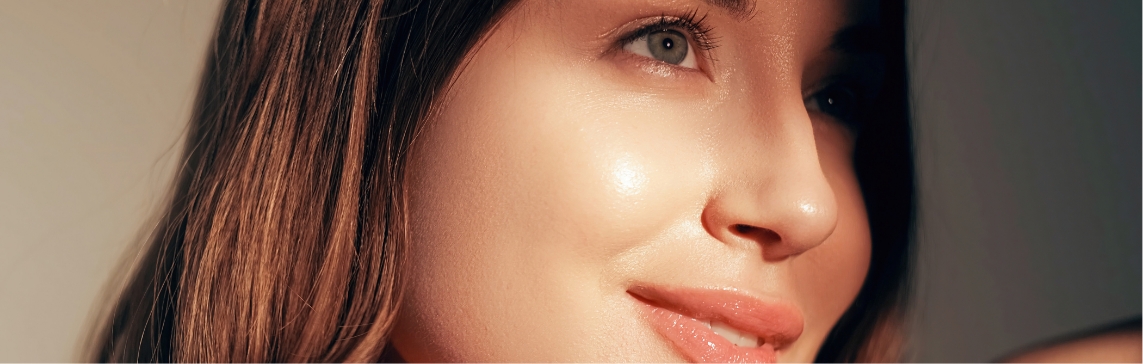Stock photograph of a model: a woman with warm light on her skin looks off to the side and smiles slightly
